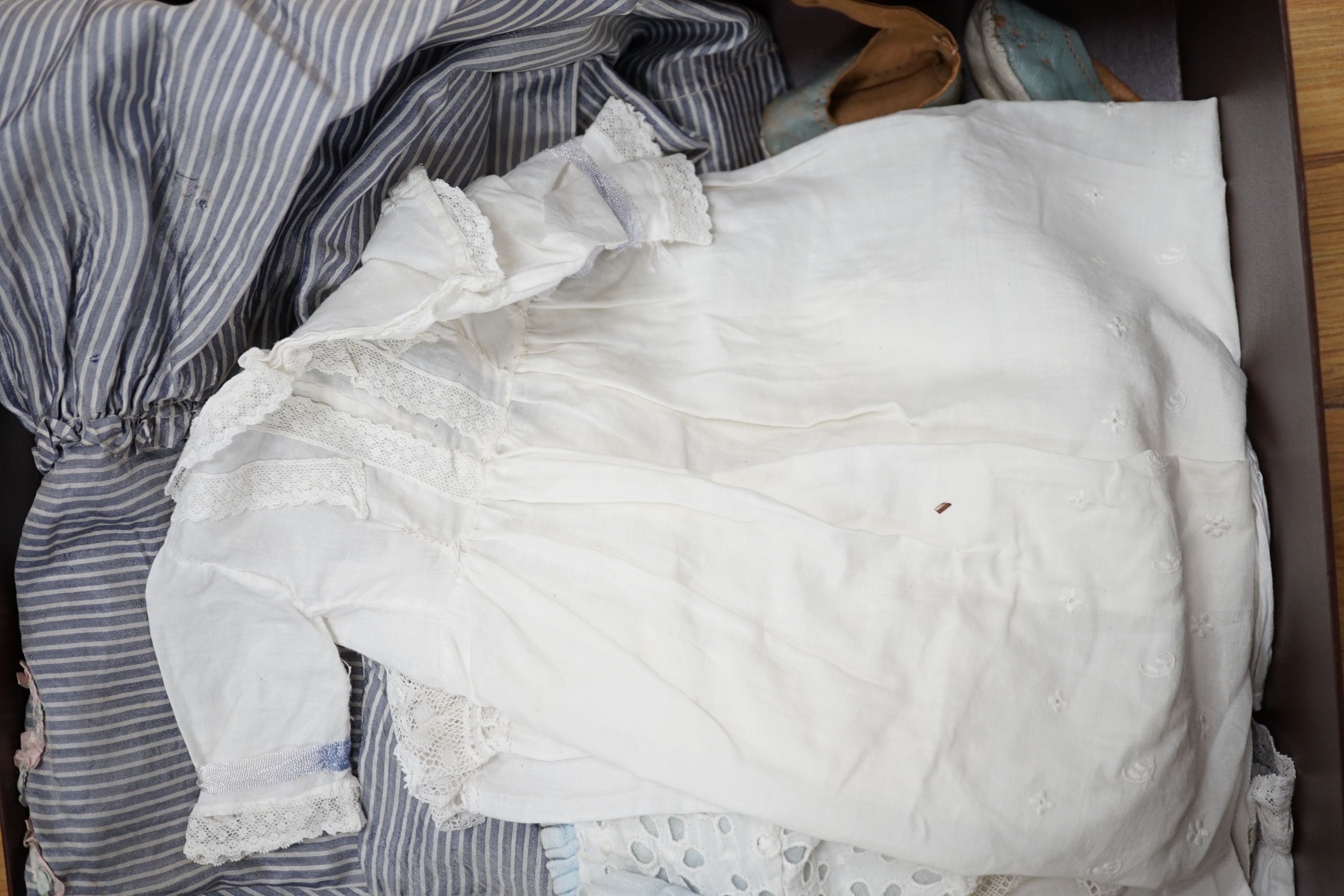 A small collection of doll's clothes from late 19th to mid 1930's, including a brown straw hat